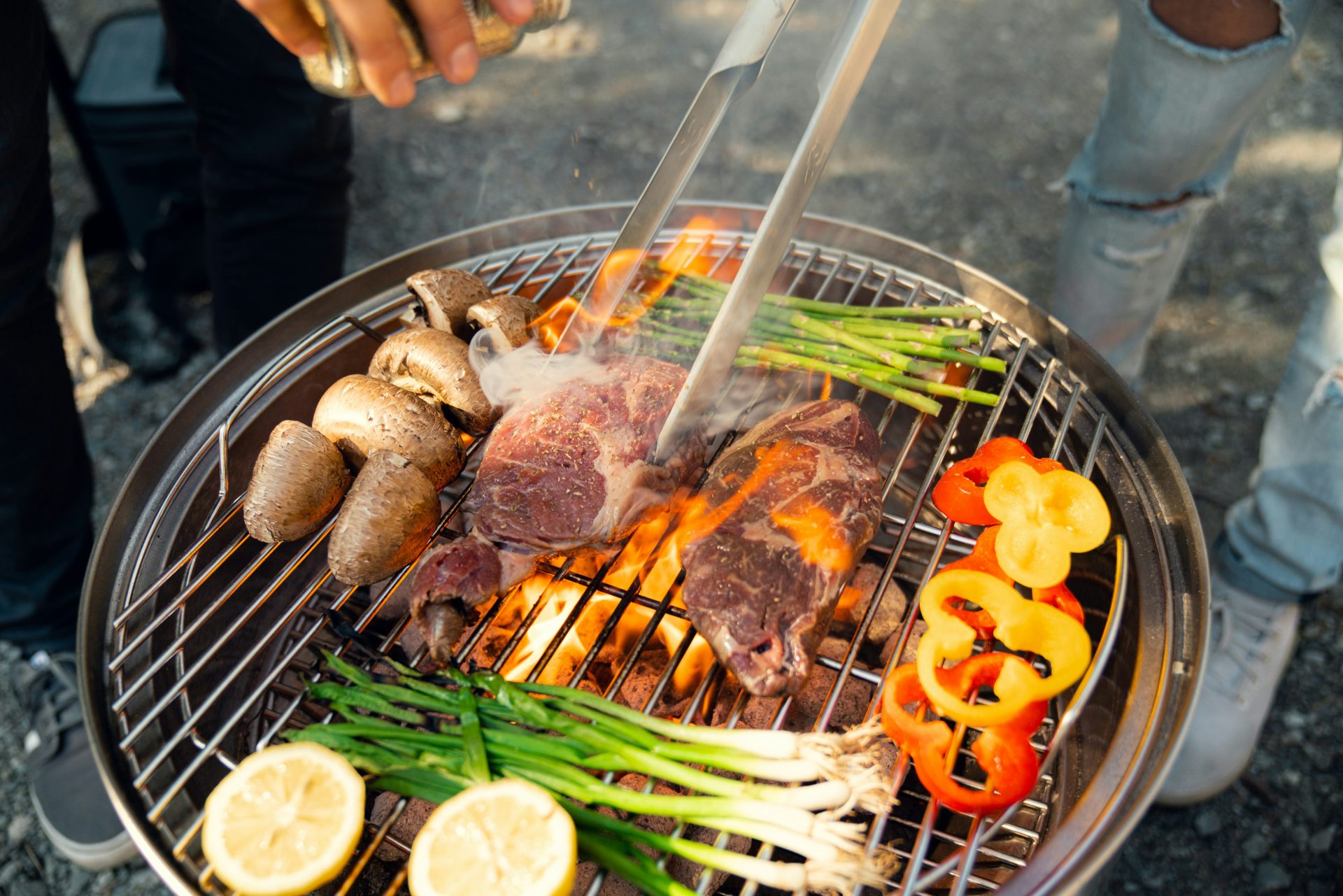 Eine Person bereitet Essen auf einem Grill zu.